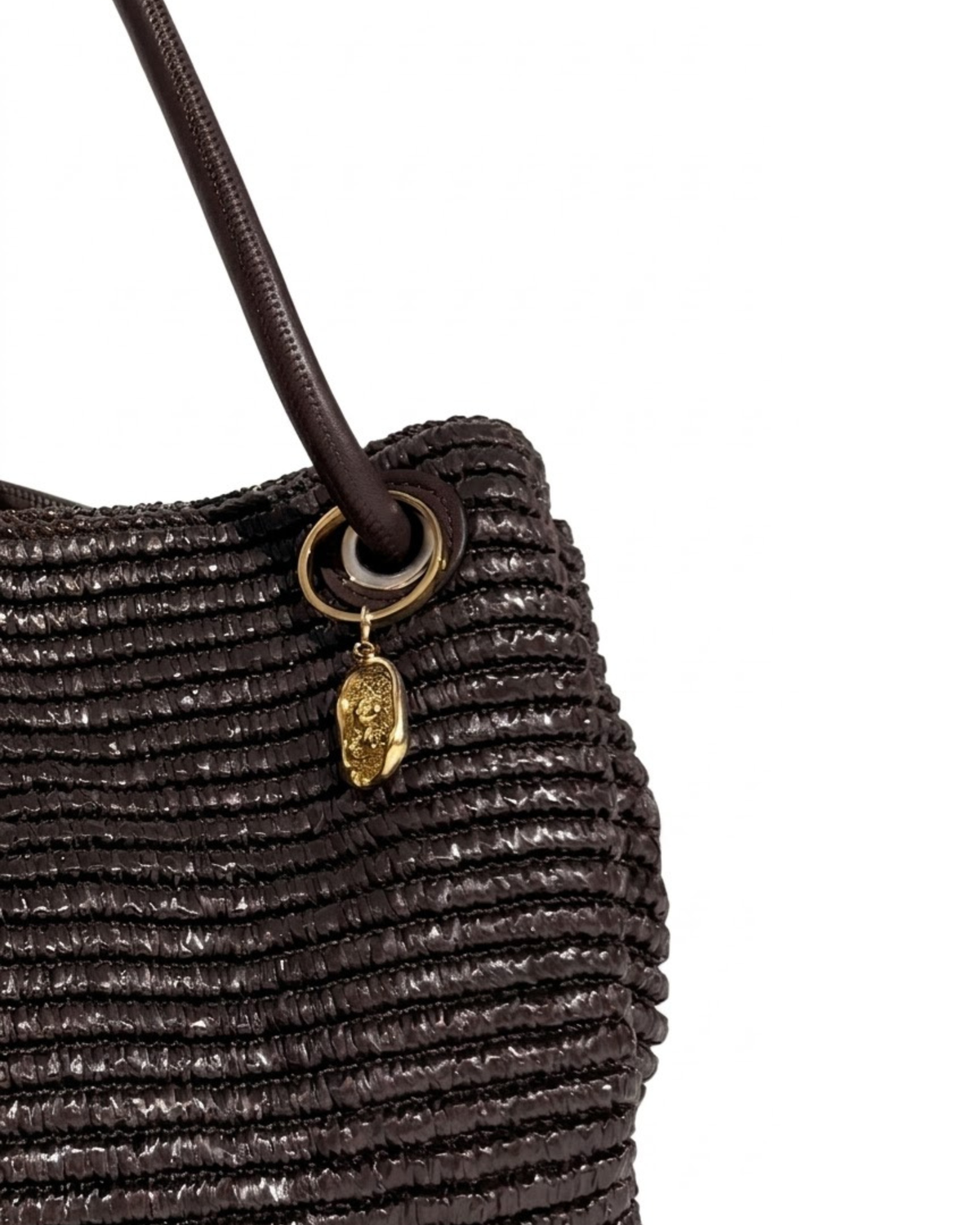 Gold BagBit - Aufnahme einer dunkelbraunen, strukturierten Tasche, verziert mit einem ovalen, goldenen Anhänger, der einen kleinen Teddybären in einem strukturierten Relief zeigt.