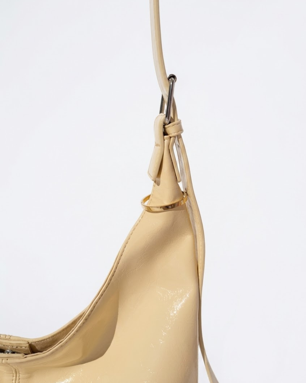 Gold Bag Clip - Nahaufnahme des Henkels einer gelbfarbenen Ledertasche, verziert mit einem eleganten goldenen Metallring.