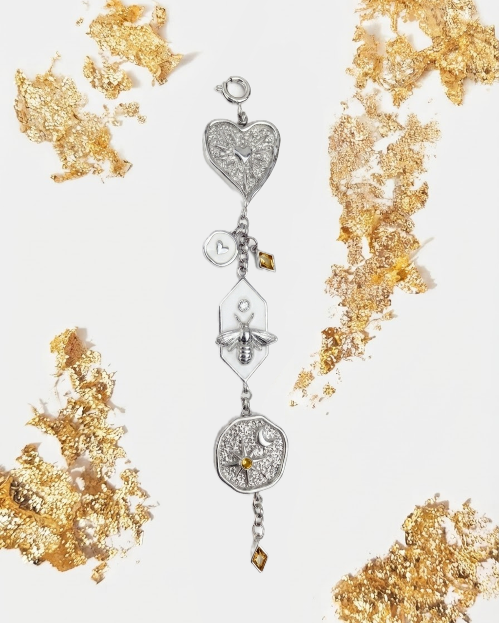 Silber Bag Charm - Mehrteiliger silberner Taschenanhänger mit Herz, Motte und Medaillon, umgeben von goldenen Blattgold-Akzenten. 