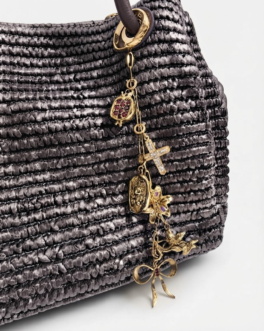 Gold Single Chain - Dunkelbraune Tasche mit einer goldfarbenen Kette am Taschenhenkel, verziert mit goldenen Anhängern wie Granatapfel, Kreuz, Teddybär-Medaillon, Blume, Engel und Schleife.