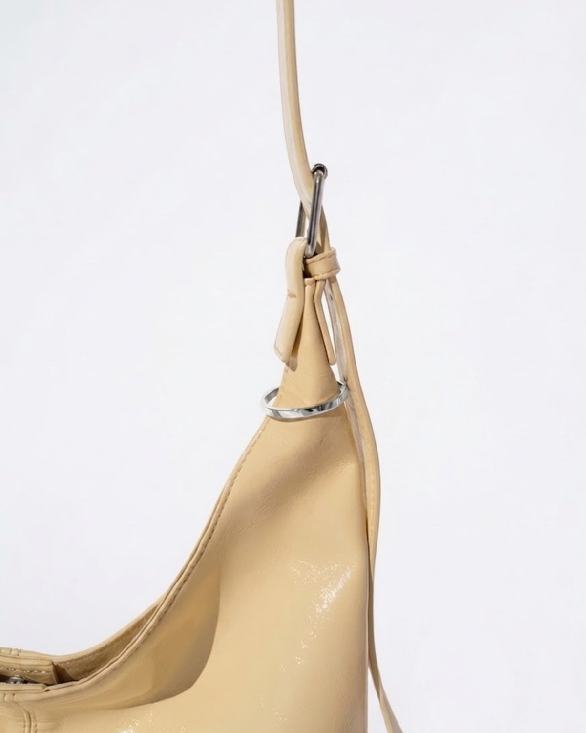 Silber Bag Clip - Nahaufnahme des Henkels einer gelbfarbenen Ledertasche, verziert mit einem eleganten silbernen Metallring.