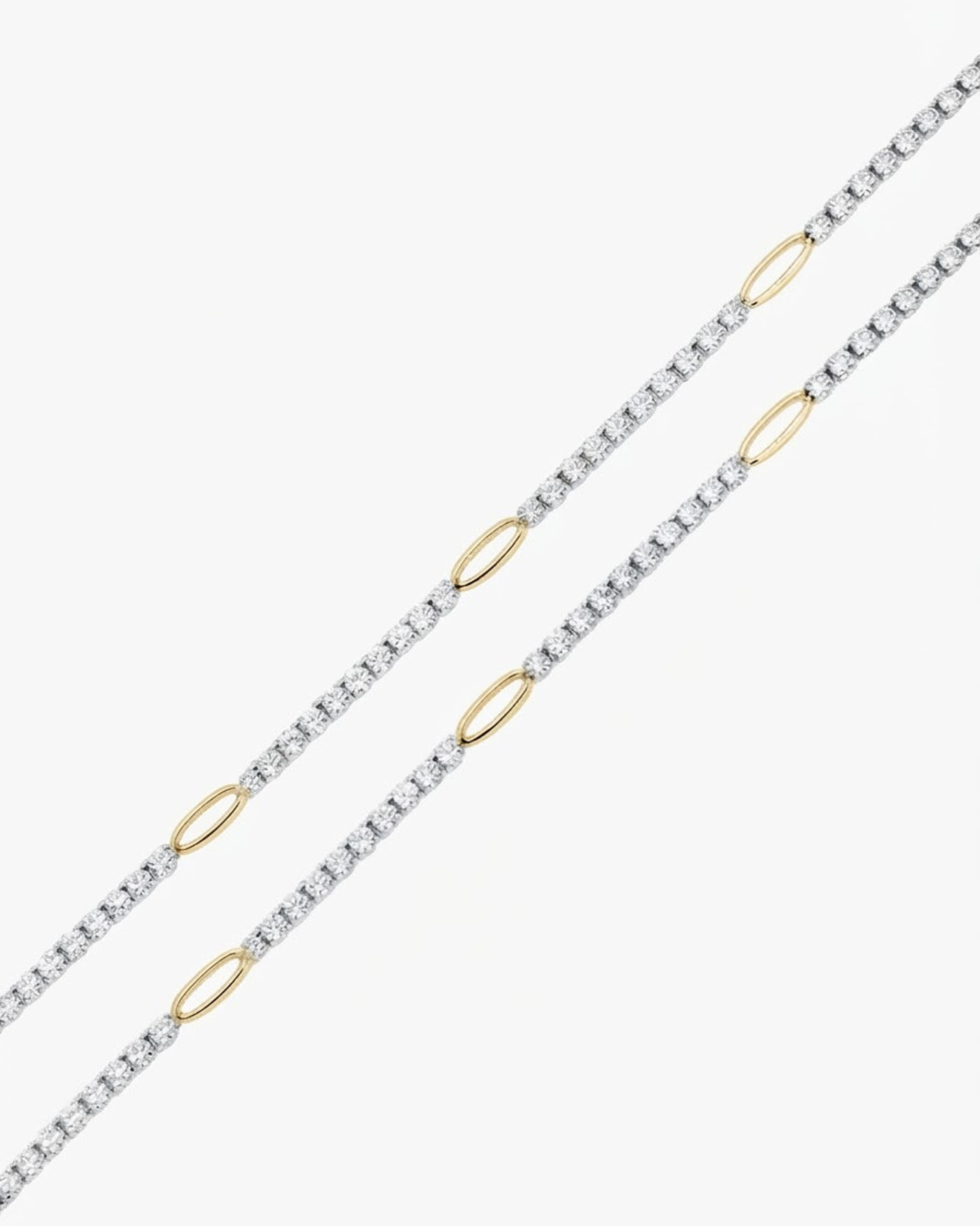 Gold Strass Duo Chain - Zwei parallele Strassketten mit klaren Kristallen, unterbrochen von goldenen ovalen Kettengliedern, auf weißem Hintergrund.
