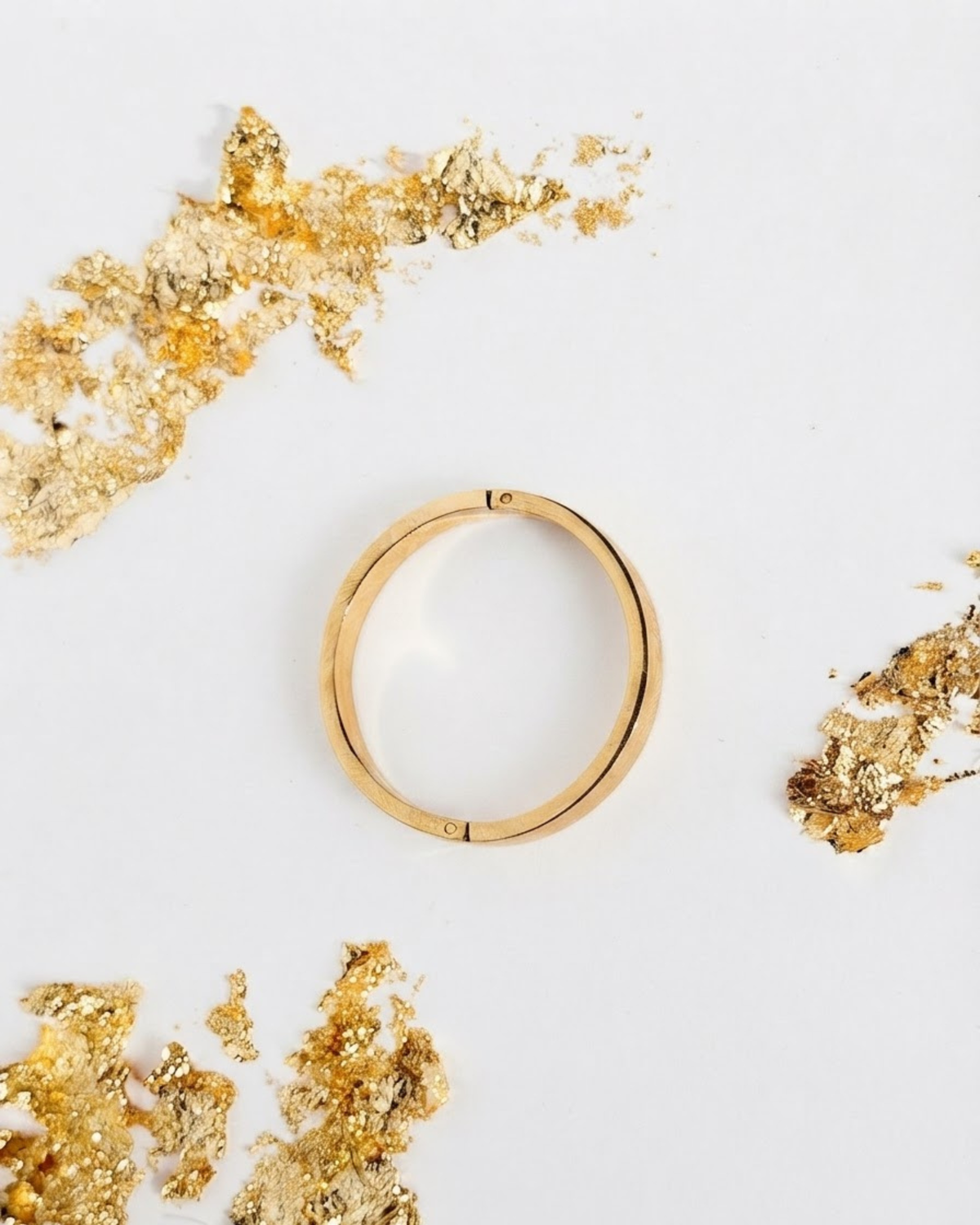 Gold Bag Clip - Eleganter, kreisförmiger Gold-Clip, isoliert auf weißem Hintergrund, umgeben von dekorativen Blattgold-Akzenten.
