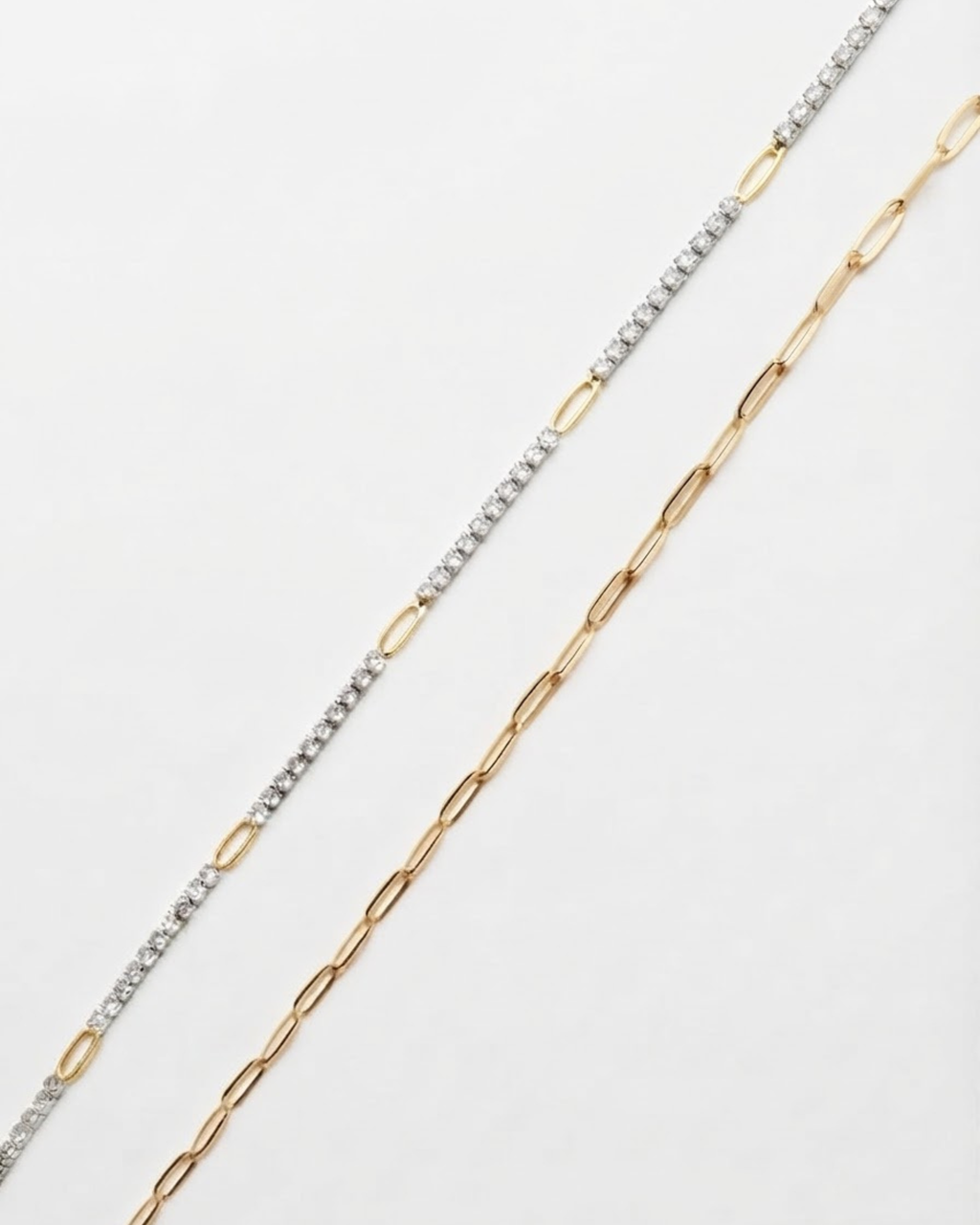 Gold Mixed Duo Chain - Zwei goldfarbene Ketten nebeneinander vor weißem Hintergrund: links eine Kette mit glitzernden Strasssteinen, rechts eine Kette mit länglichen klassischen Gliedern.