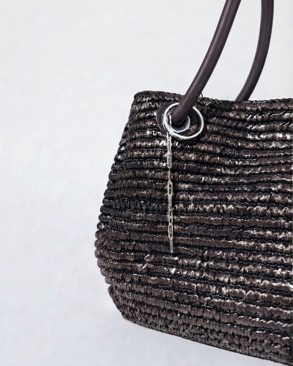 Silber Single Chain - Dunkelbraune Tasche mit einer kurzen, herabhängenden silberfarbener Kette am Taschenhenkel.