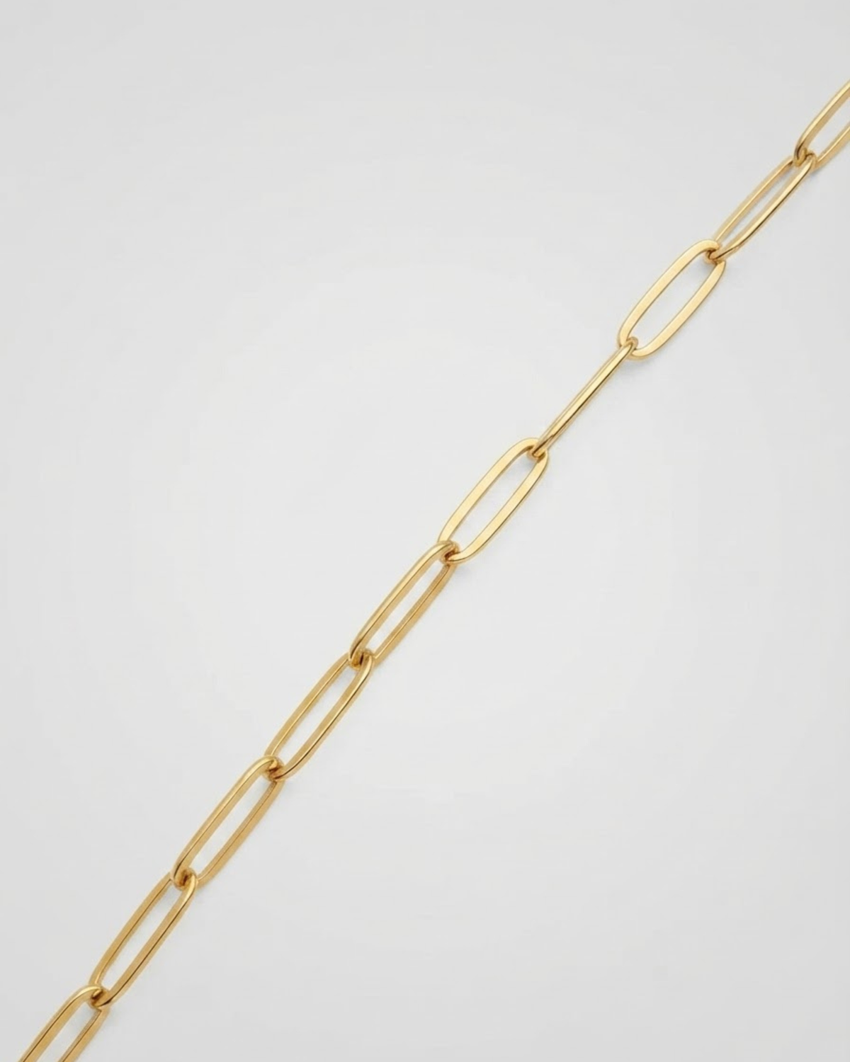 Gold Single Chain - Nahaufnahme einer goldfarbenen Kette mit länglichen Gliedern vor hellem Hintergrund.