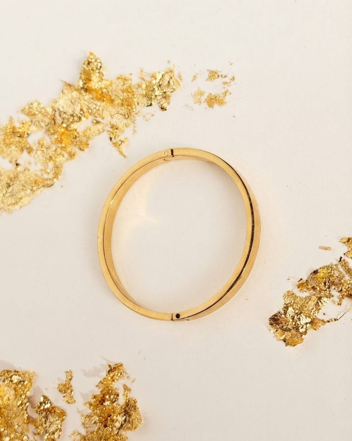 Gold Bag Clip - Eleganter, kreisförmiger Gold-Clip, isoliert auf weißem Hintergrund, umgeben von dekorativen Blattgold-Akzenten.