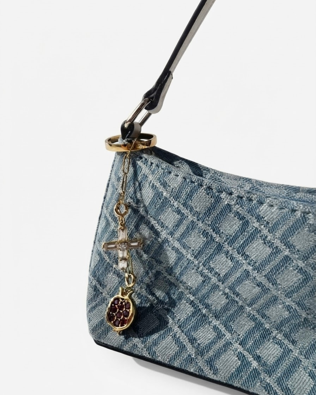 Gold Bag Bit - Blau-gemusterte Denim-Schultertasche mit einer kurzen goldenen Kette am Taschenhenkelt, verziert mit einem Kreuz- und einem Granatapfel-Anhänger.