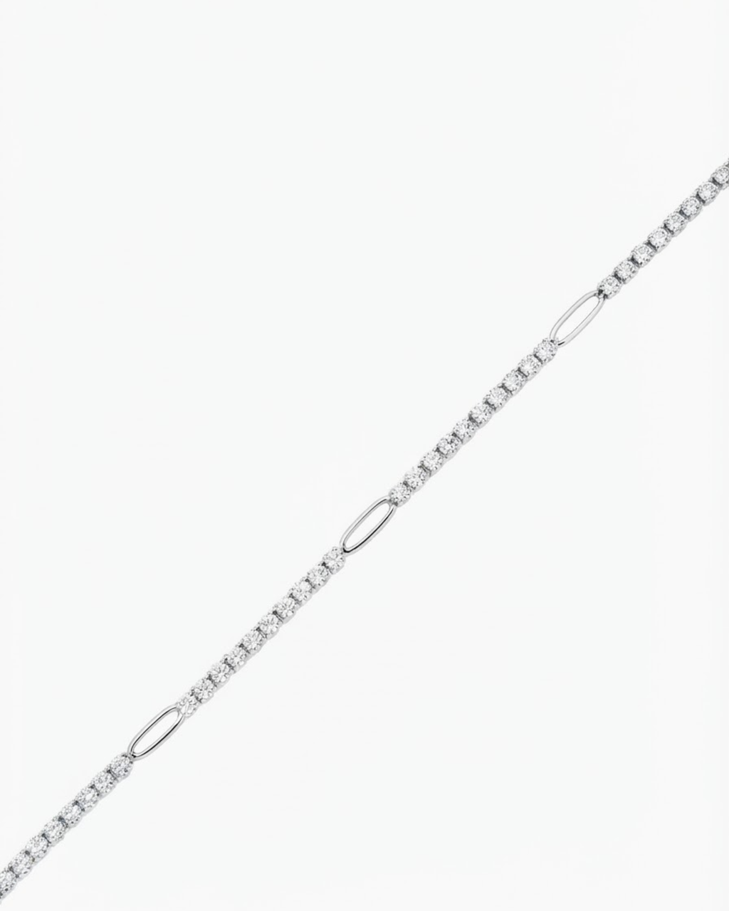 Silber Strass Single Chain - Strasskette mit funkelnden Schmucksteinen, die in regelmäßigen Abständen durch silberfarbene ovale Glieder unterbrochen wird, vor hellem Hintergrund.