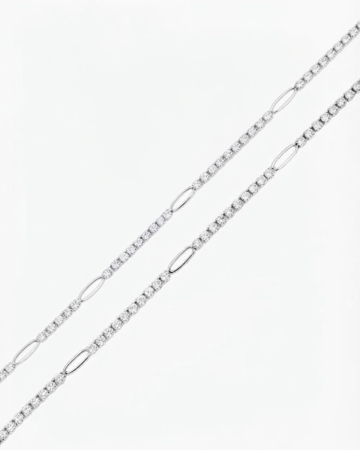 Silber Strass Duo Chain - Zwei parallele Strassketten mit klaren Kristallen, unterbrochen von silbernen ovalen Kettengliedern, auf weißem Hintergrund.