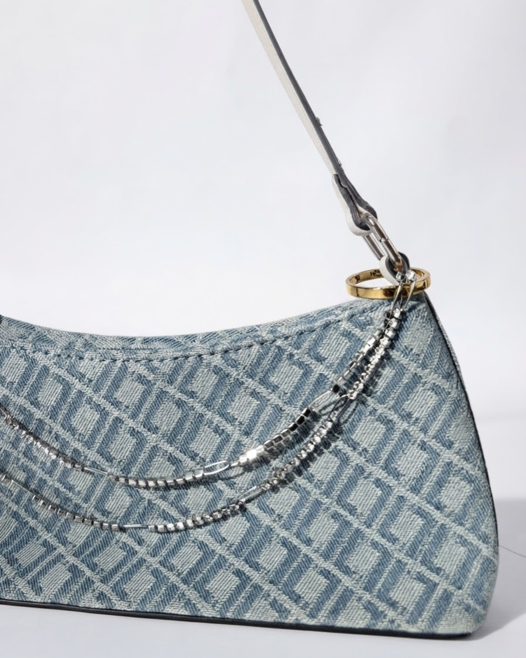 Silber Strass Duo Chain - Hellblaue Denim-Handtasche mit Allover-Monogramm-Muster, verziert mit zwei übereinanderliegenden, silberfarbenen und strassbesetzten Ketten, die zwischen den Taschenhenkeln angebracht sind.