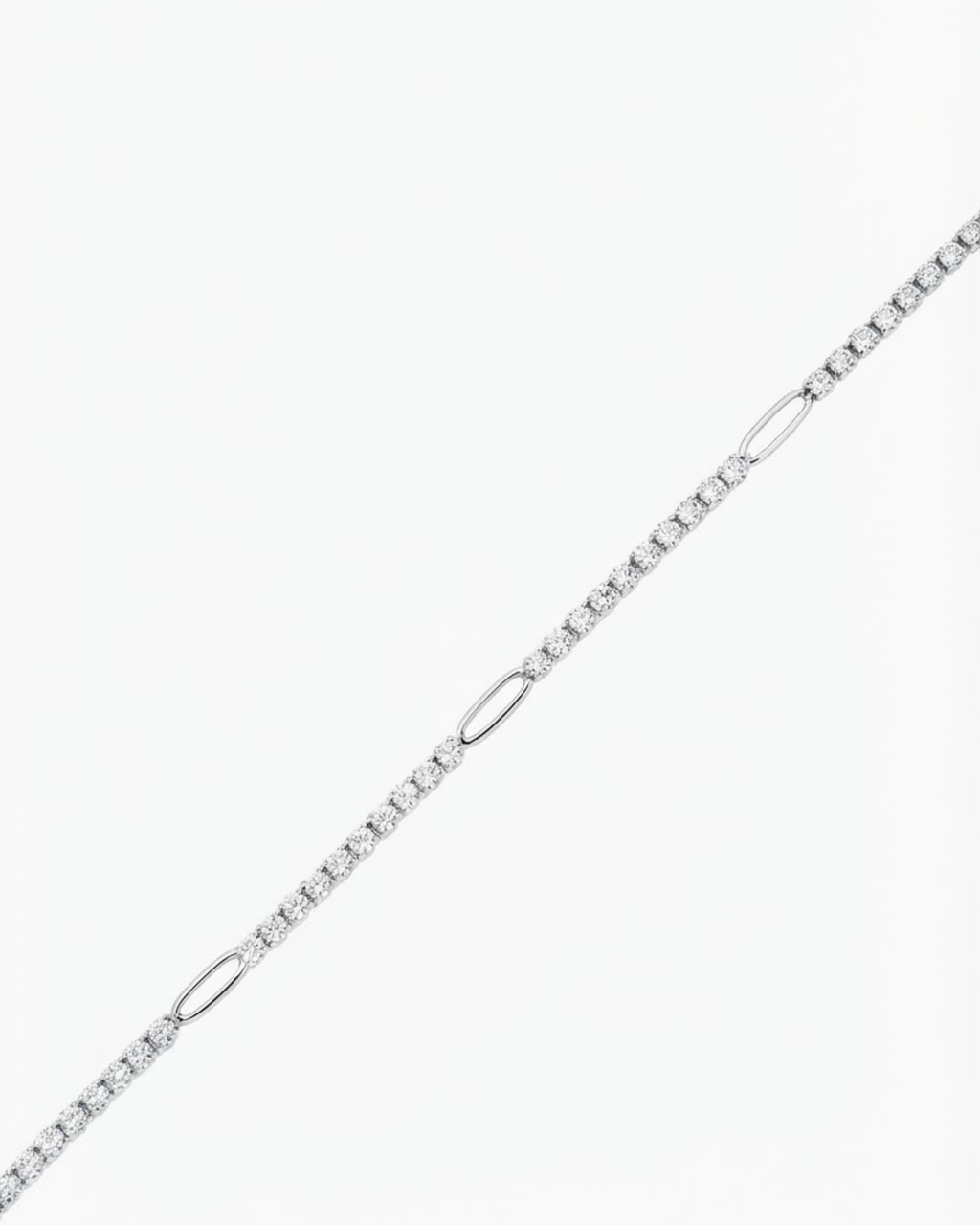 Silber Strass Bag Chain - Strasskette mit funkelnden Schmucksteinen, die in regelmäßigen Abständen durch silberfarbene ovale Glieder unterbrochen wird, vor hellem Hintergrund.