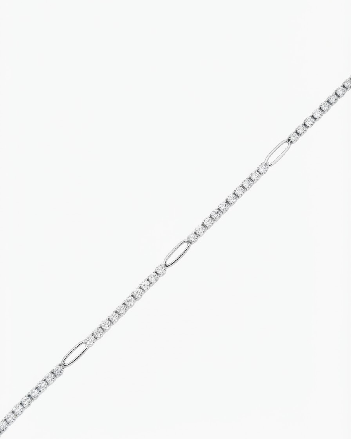 Silber Strass Bag Chain - Strasskette mit funkelnden Schmucksteinen, die in regelmäßigen Abständen durch silberfarbene ovale Glieder unterbrochen wird, vor hellem Hintergrund.