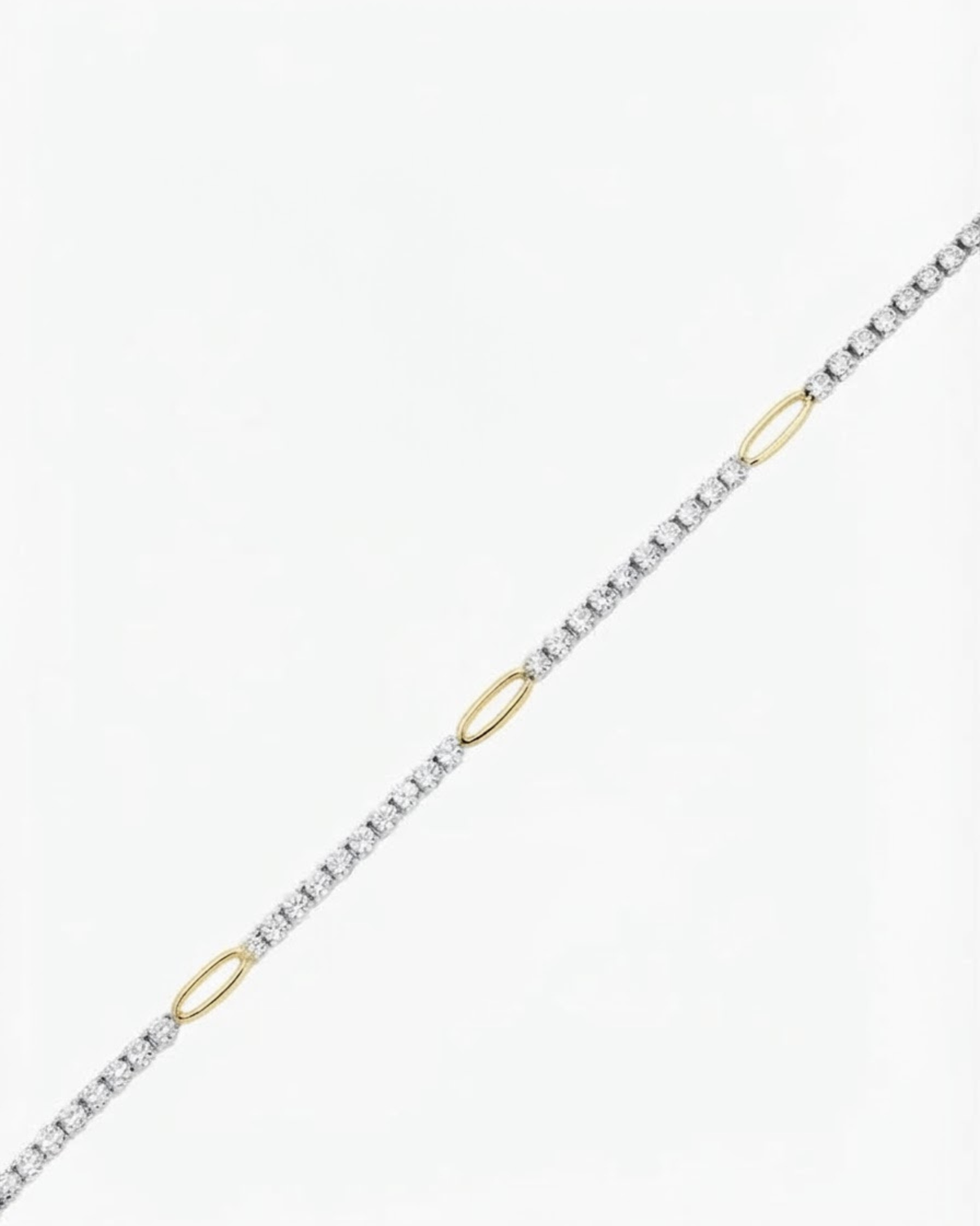 Gold Strass Single Chain - Strasskette mit funkelnden Schmucksteinen, die in regelmäßigen Abständen durch goldfarbene ovale Glieder unterbrochen wird, vor hellem Hintergrund.